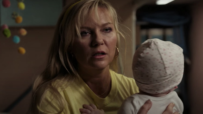 Kirsten Dunst chemise jaune tenant bébé