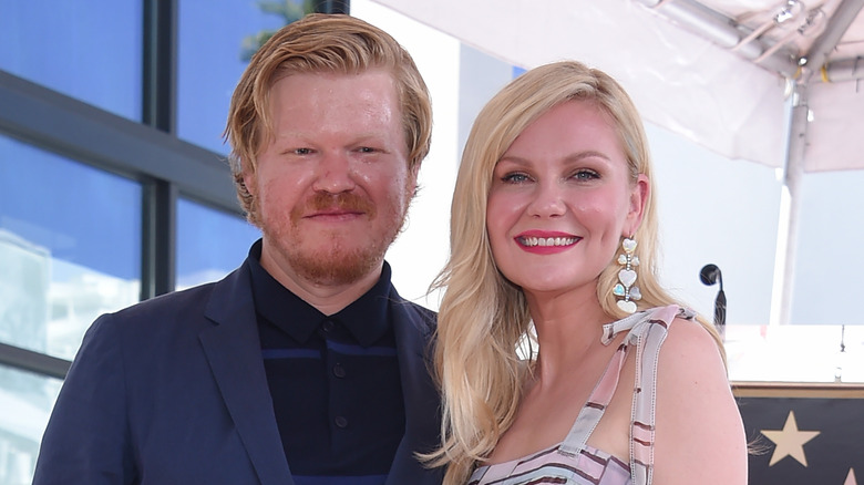 Jesse Plemons et Kirsten Dunst debout souriant