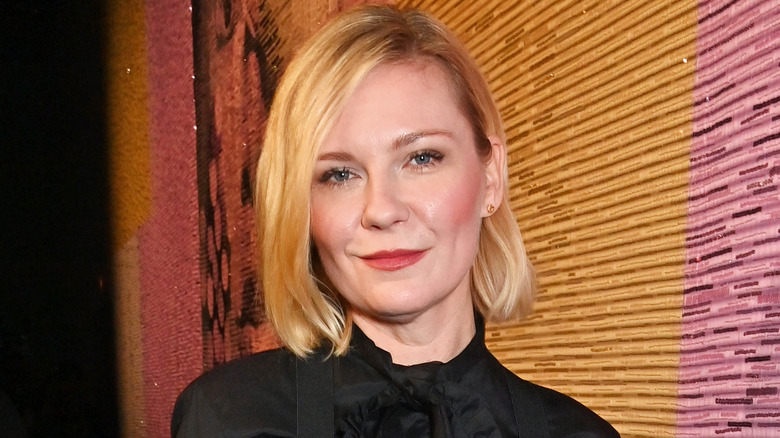 Kirsten Dunst robe noire souriante