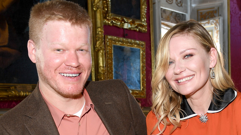 Jesse Plemons et Kirsten Dunst souriant fond de peintures