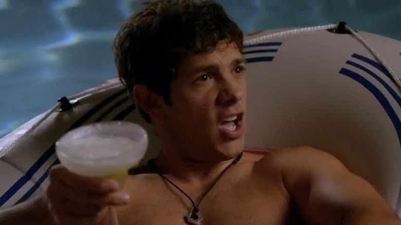 Michael Rady tenant un verre sur un flotteur de piscine