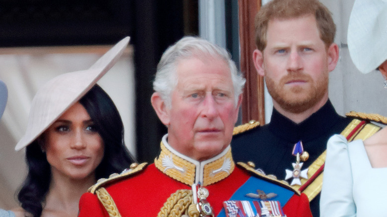 Meghan Markle, le prince Charles et le prince Harry debout