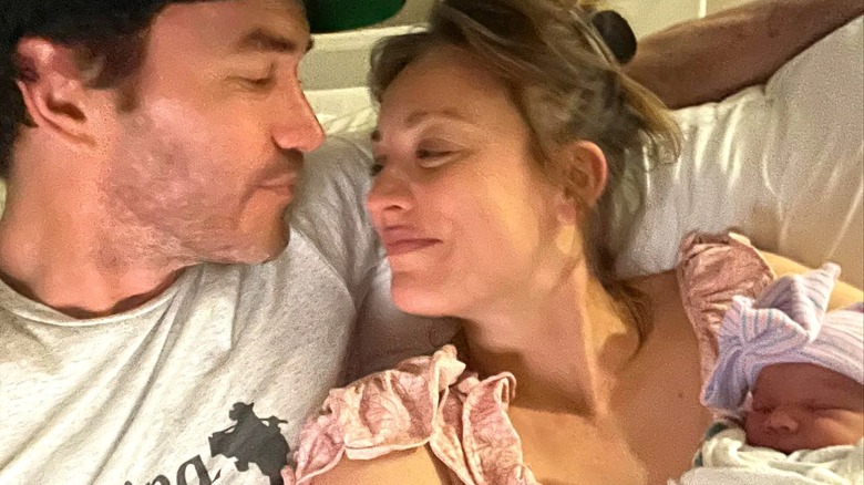 Tom Pelphrey et Kaley Cuoco tenant un nouveau-né