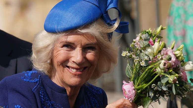 La reine Camilla sourit en tenant un bouquet