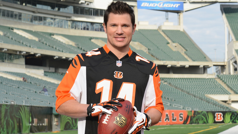 Nick Lachey portant un maillot des Bengals et tenant un ballon de football