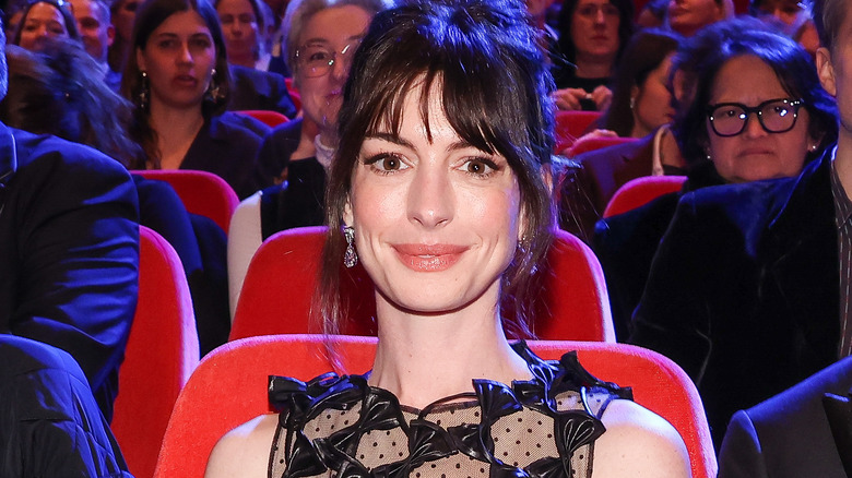 Anne Hathaway assise et souriante