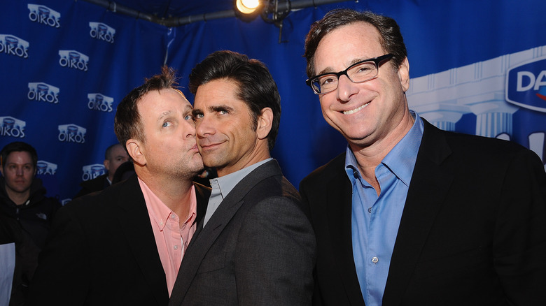 Dave Coulier embrassant John Stamos, Bob Saget souriant