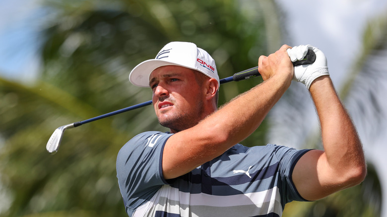 Bryson DeChambeau swings club dans un chapeau blanc