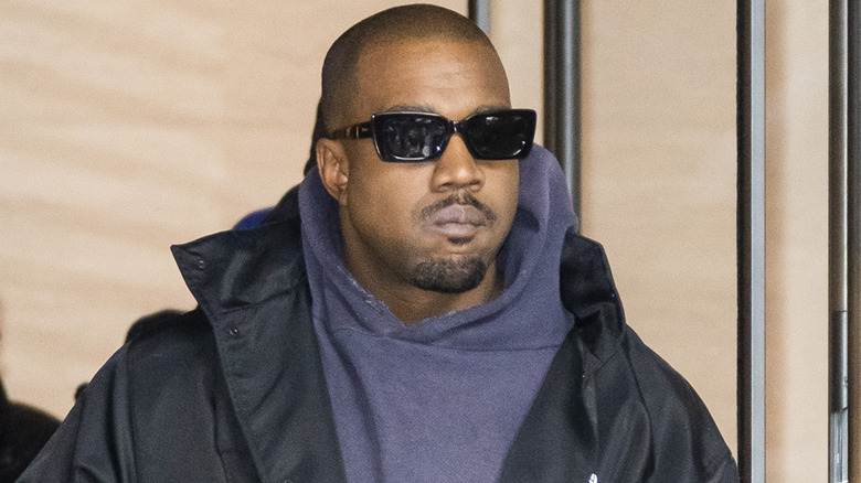 Kanye West portant un sweat à capuche gris et des lunettes noires