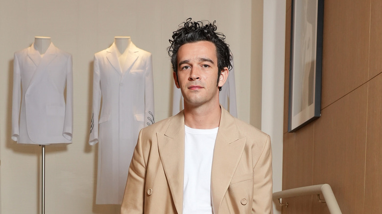 Matty Healy portant un pardessus beige