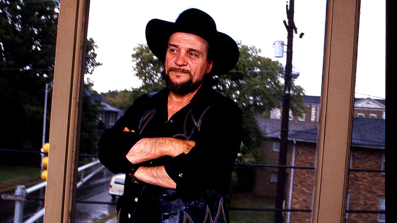 Waylon Jennings posant devant une fenêtre