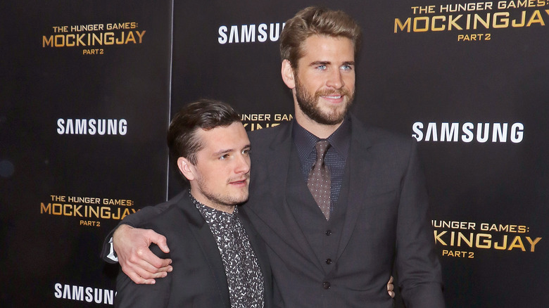 Liam Hemsworth avec un bras autour de Josh Hutcherson