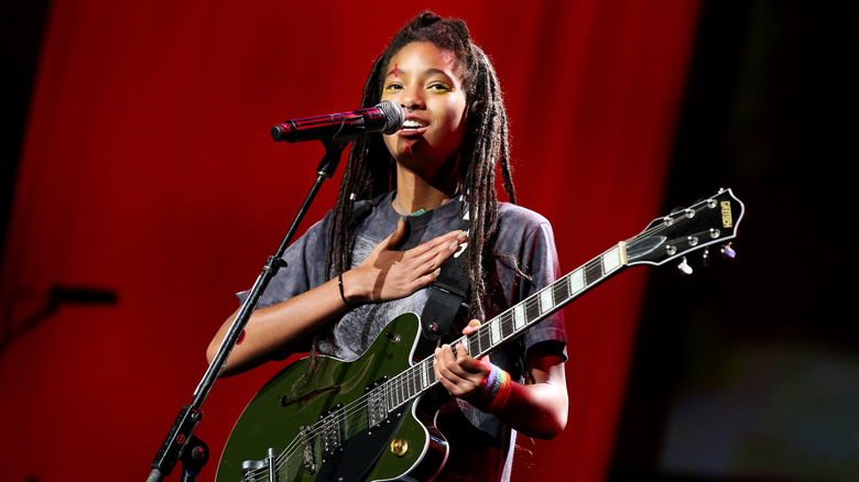 Willow Smith avec guitare, main sur la poitrine