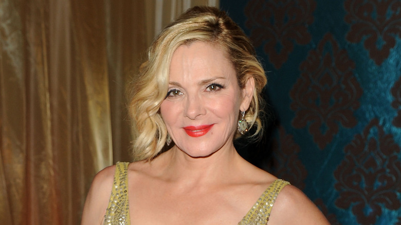 Kim Cattrall souriant aux lèvres rouges