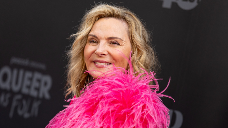 Kim Cattrall souriant plumes roses