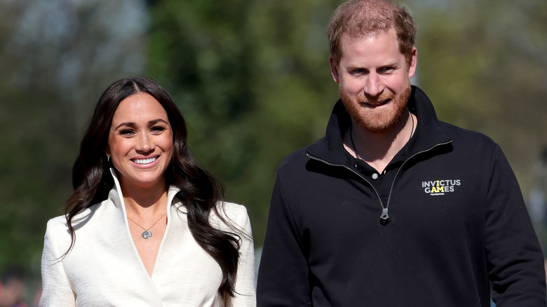 Meghan et Harry marchent sur une piste de course