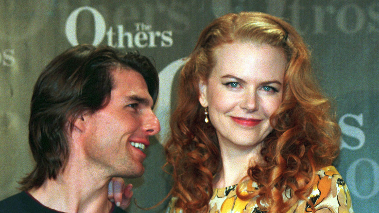 Tom Cruise chuchotant à Nicole Kidman souriante