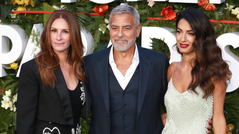 Julia Roberts souriante avec George et Amal Clooney