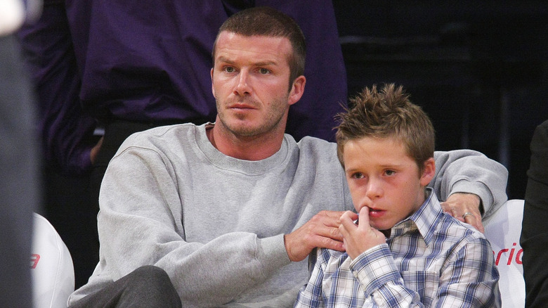 David Beckham avec la main sur l'épaule de Brooklyn Beckham