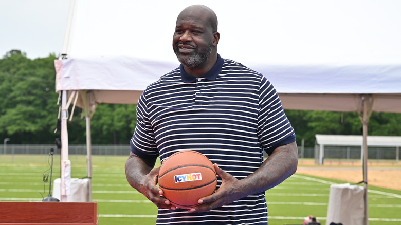 Shaquille O'Neal tient un ballon de basket