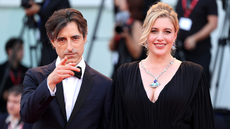 Greta Gerwig souriante avec Noah Baumbach pointant du doigt