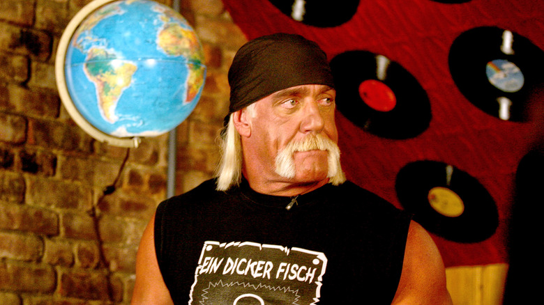 Hulk Hogan avec des albums de disques, regardant ailleurs