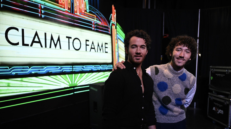 Kevin Jonas posant avec Frankie Jonas à côté de signer pour Claim to Fame