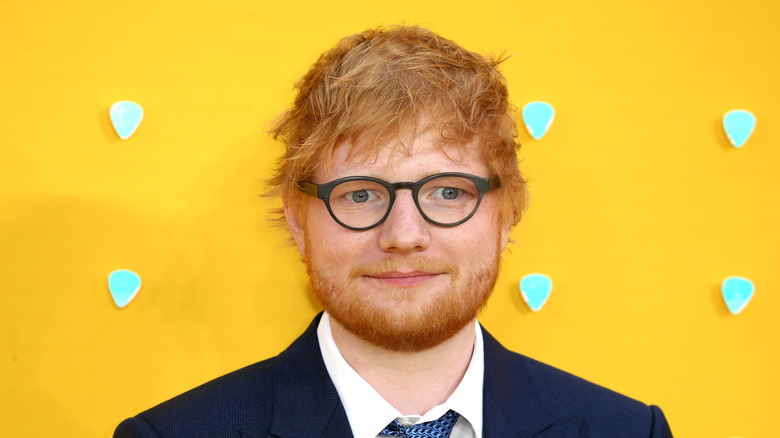 Ed Sheeran posant sur fond jaune