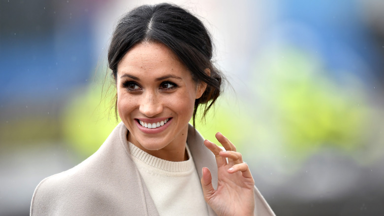 Manteau crème Meghan Markle souriant