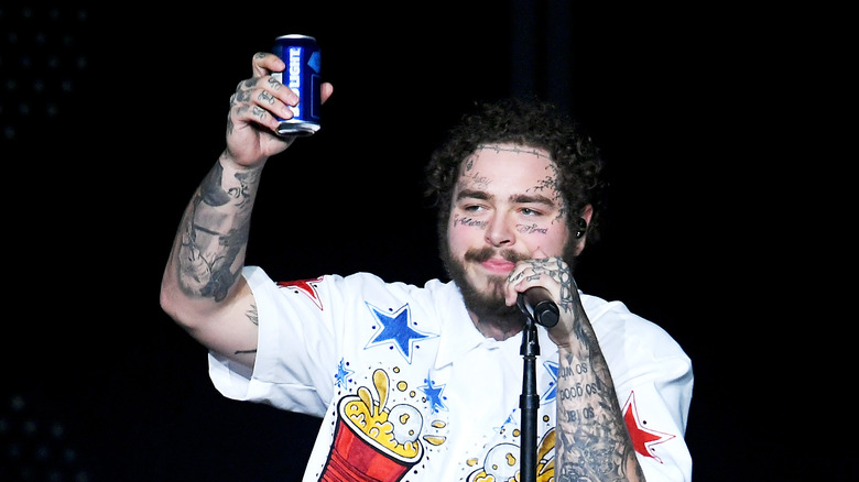 Post Malone jouant avec une canette Bud Light à la main