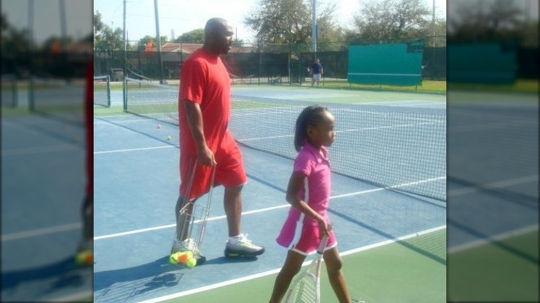 Coco et Corey Gauff marchant sur un court de tennis