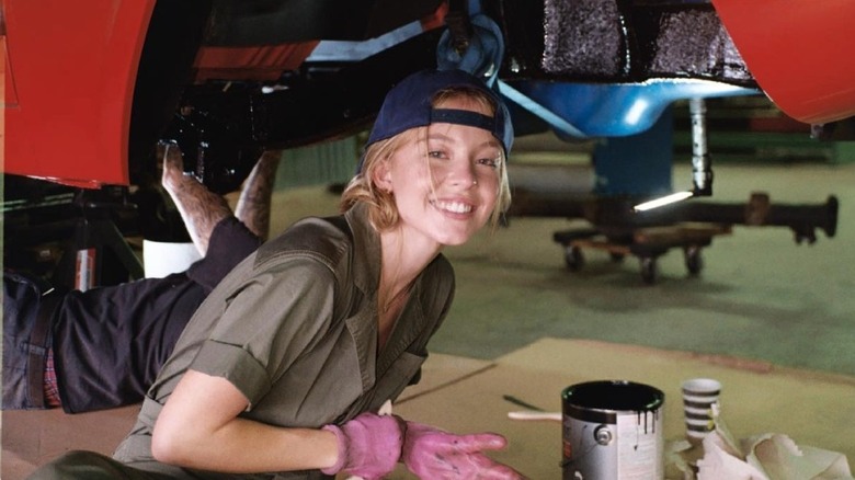 Sydney Sweeney souriant dans un garage