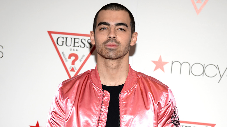 Joe Jonas posant lors d'un événement Guess