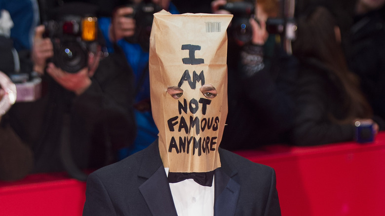 Shia LaBeouf posant avec un sac en papier