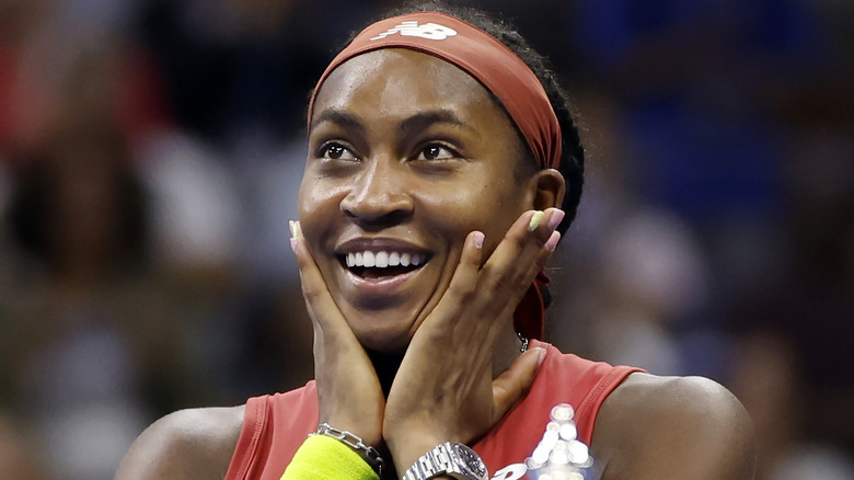 Coco Gauff souriant avec ses mains sur son visage avec enthousiasme