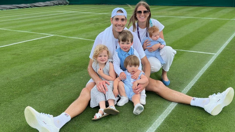 La famille Isner sourit sur un court de tennis