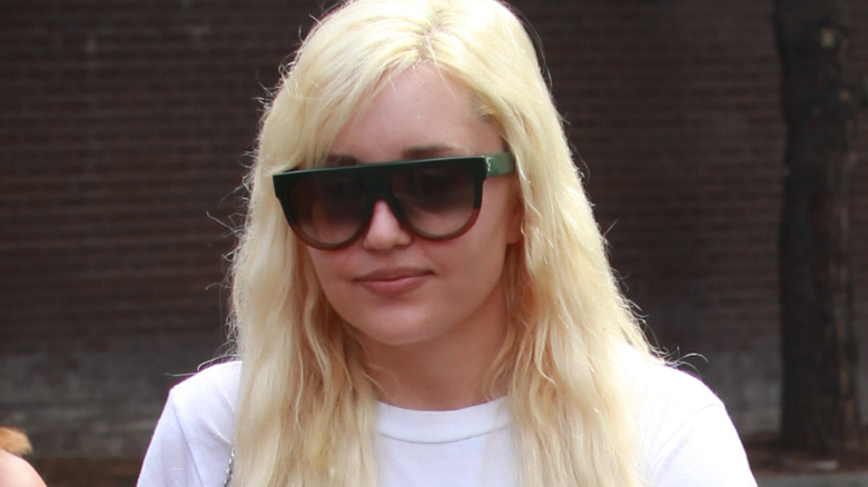 Amanda Bynes marche avec des lunettes de soleil