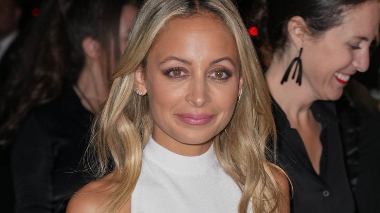 Nicole Richie souriante en robe blanche