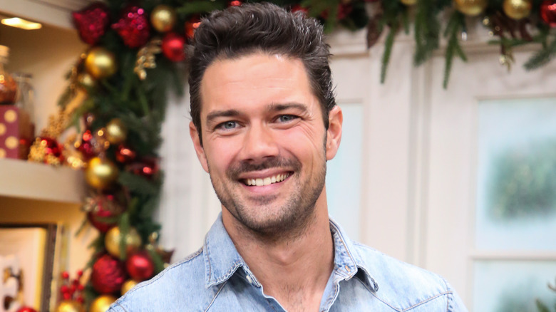 Ryan Paevey souriant avec une décoration de vacances