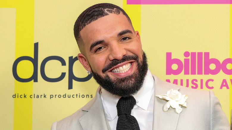 Drake souriant en costume