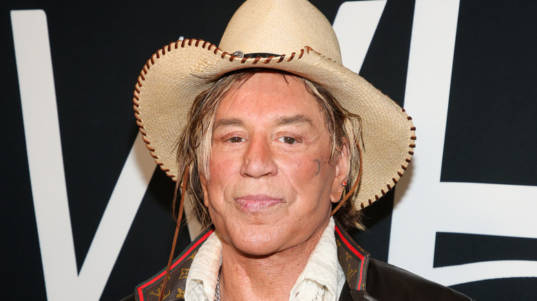 Mickey Rourke posant avec un chapeau de cowboy en paille