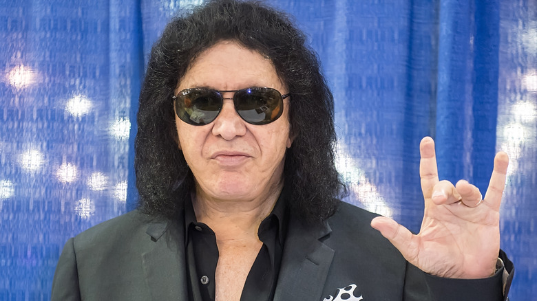 Gene Simmons posant et faisant un signe de la main