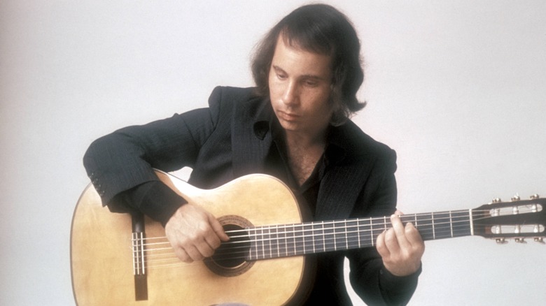 Paul Simon pose avec une guitare