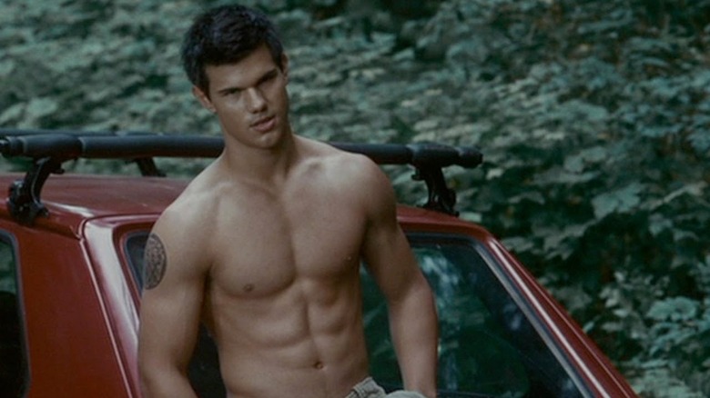 Jacob Black appuyé contre une voiture, torse nu