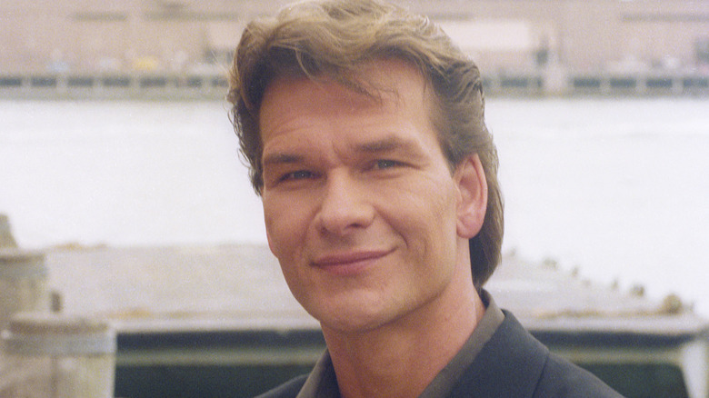 Patrick Swayze posant en extérieur