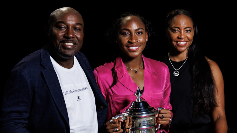 Corey, Coco et Candi Gauff posant avec Coco tenant son trophée de l'US Open