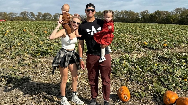 La famille Mahomes posant dans un champ de citrouilles