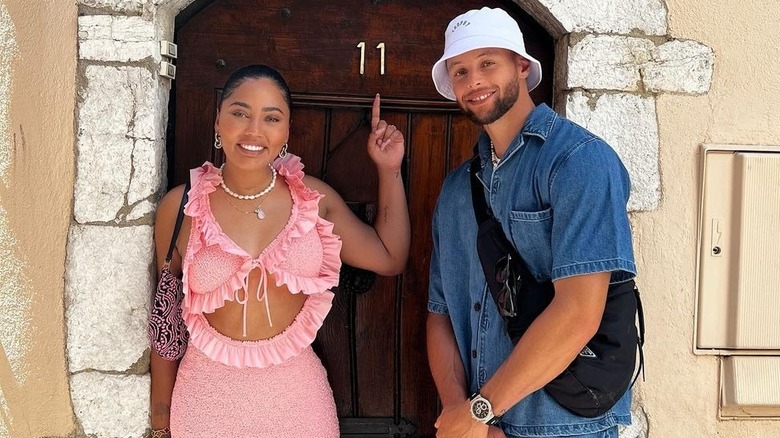 Ayesha et Steph Curry posant devant la porte