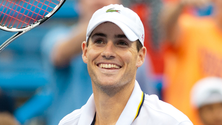 John Isner sourit lors d'une compétition de tennis en 2013