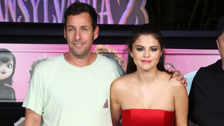 Adam Sandler posant avec son bras autour de Selena Gomez